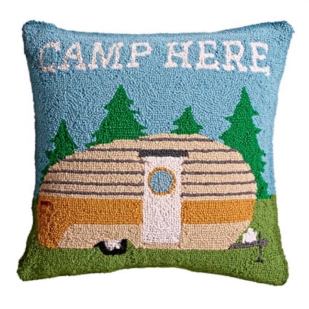 โCamp Here" hooked throw pillow featuring a camper and trees design.